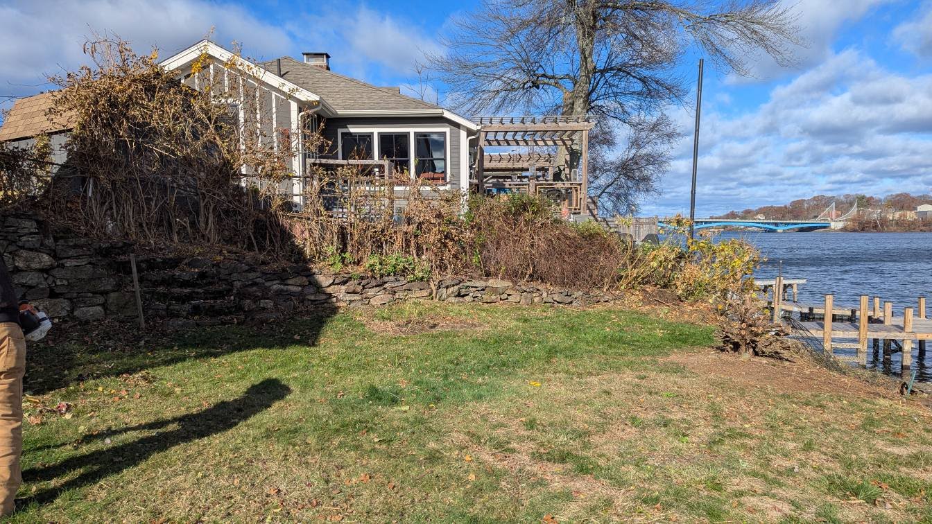 Beautiful waterfront property landscaping with stone walls